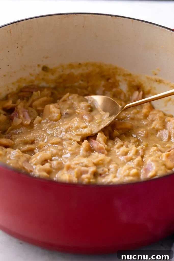 Southern-Style Creamy Butter Beans Recipe: Comforting Soul Food 5 creamy butter beans in a dutch oven with a gold spoon