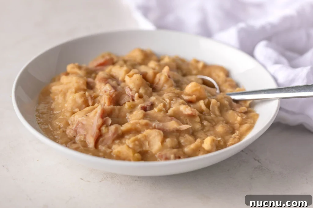 Southern-Style Creamy Butter Beans Recipe: Comforting Soul Food 6 bowl of creamy butter beans with a silver spoon and white napkin in the background