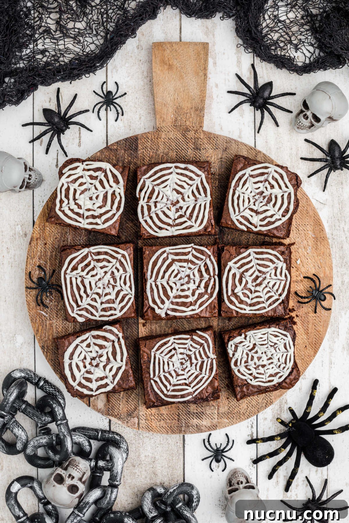 Spider Web Brownies: How to Make Spooky Halloween Brownies Quickly 2 Overhead shot of a board with brownies decorated with spider webs surrounded by spiders.