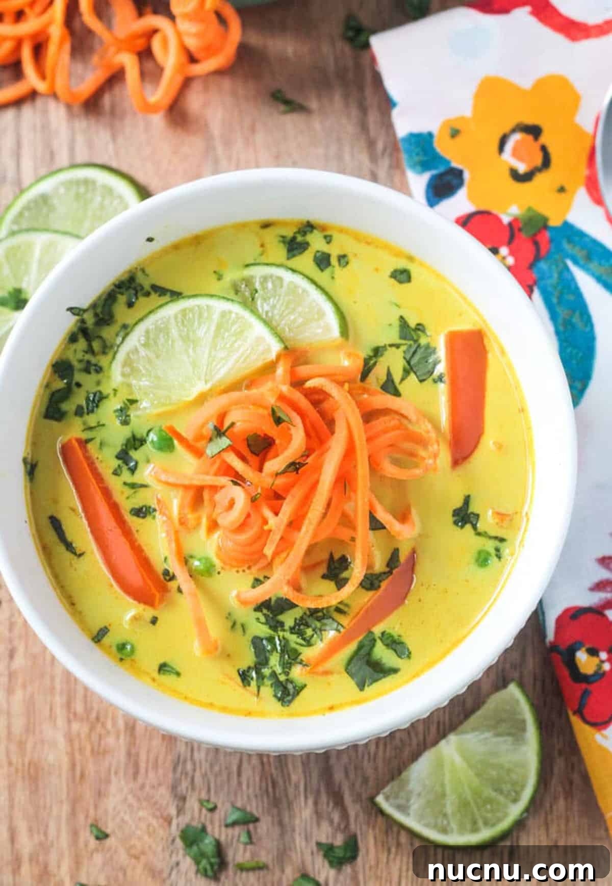 Coconut Curry Soup w/ Sweet Potato Noodles - This flavorful dairy free soup can be made in just about 30 minutes! Comforting and spicy, it will warm you from the inside out. Golden yellow coconut curry soup topped with spiralized sweet potatoes and fresh cilantro.