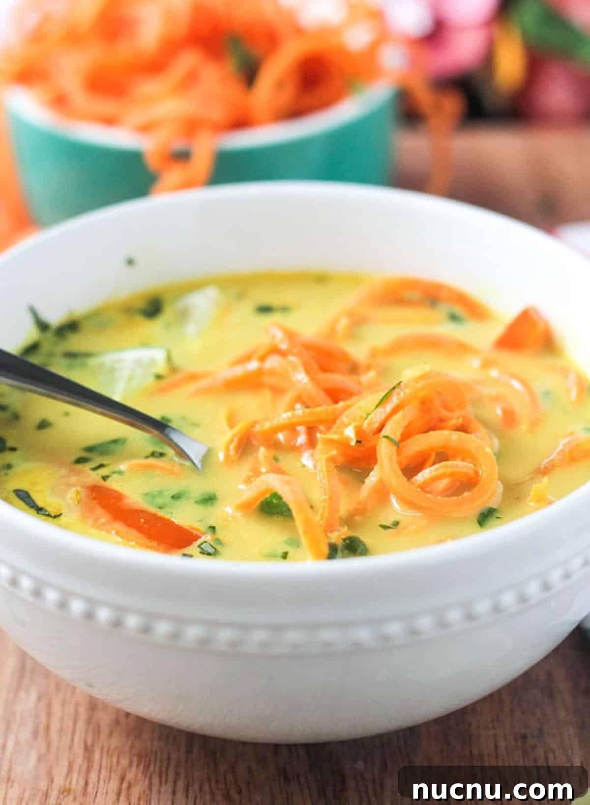 Coconut Curry Soup w/ Sweet Potato Noodles - Comforting and fun to eat. Close up of sweet potato noodles in a bowl of curry soup.