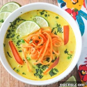 Creamy Coconut Curry Soup with Lime and Cilantro 2 Golden yellow coconut curry soup topped with spiralized sweet potatoes and fresh cilantro.