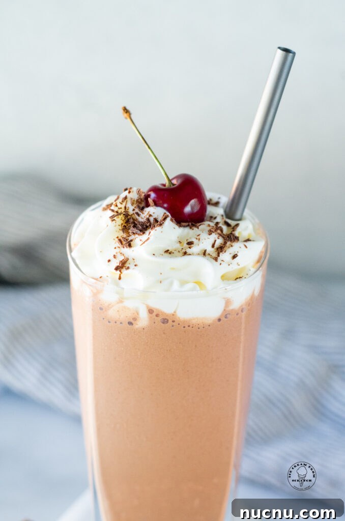 Decadent Chocolate Peanut Butter Milkshake Recipe 5 close up of top of a chocolate peanut butter milkshake with a cherry on top