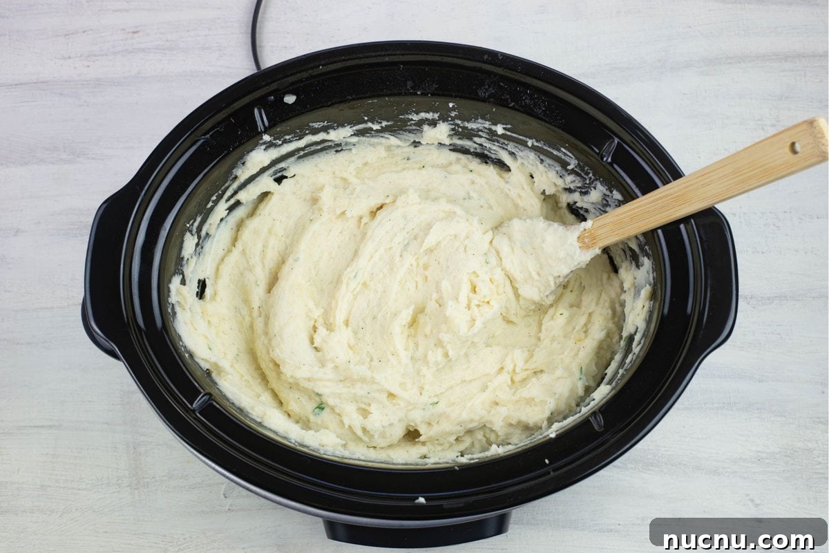 Million-Dollar Slow Cooker Mashed Potatoes Recipe 6 Crock Pot filled with creamy mashed potatoes.