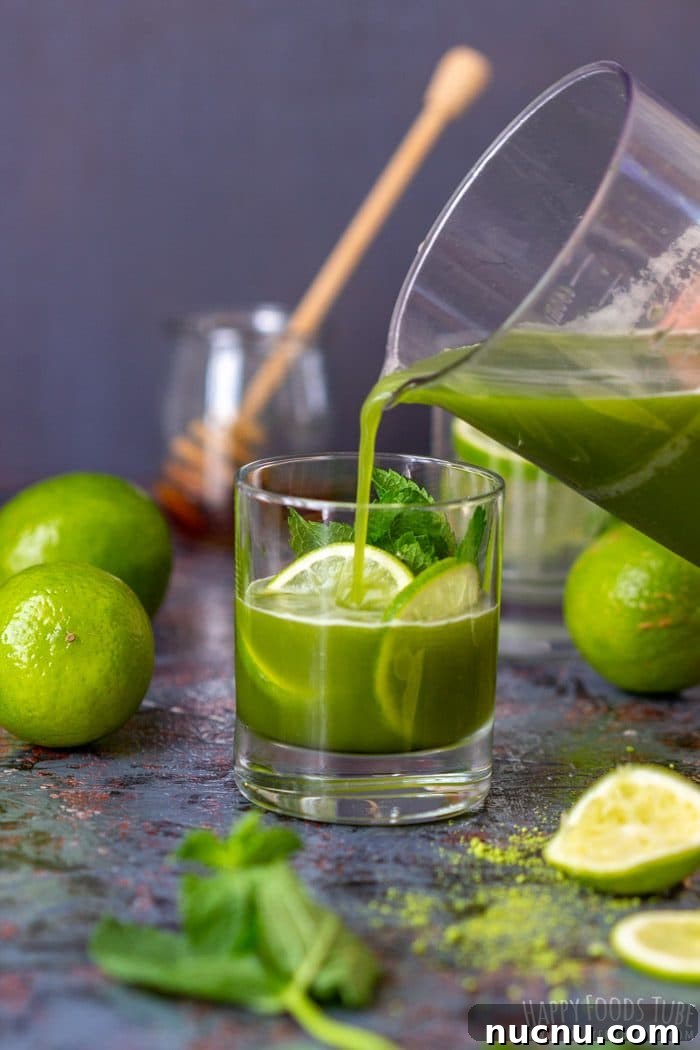 Chilled Matcha Iced Tea Recipe for Refreshing Green Tea Drinks 6 Pouring iced matcha tea into a glass with lime and mint.