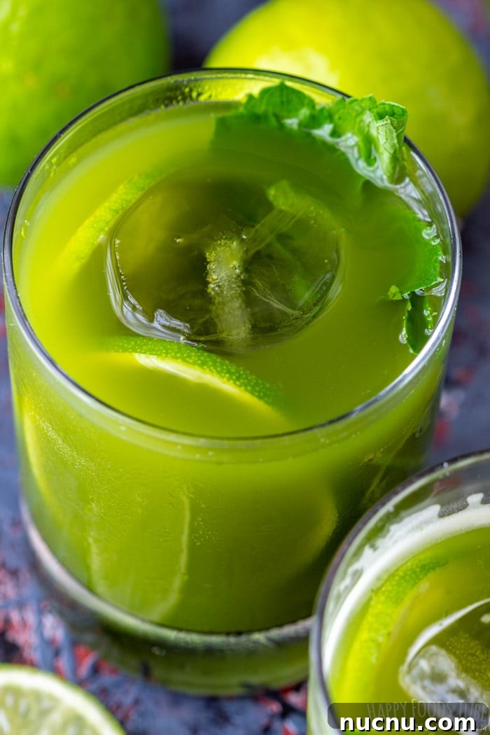 Chilled Matcha Iced Tea Recipe for Refreshing Green Tea Drinks 7 Close-up of iced matcha tea with lime slice and mint leaves.