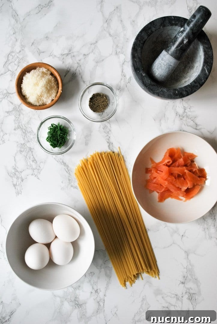 Creamy Smoked Salmon Carbonara Recipe for Quick Weeknight Dinners 3 Ingredients for smoked salmon carbonara spread out on the kitchen counter ready to be prepared.