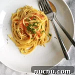 Creamy Smoked Salmon Carbonara Recipe for Quick Weeknight Dinners 6 a plate with creamy smoked salmon spaghetti carbonara beside a napkin and cutlery