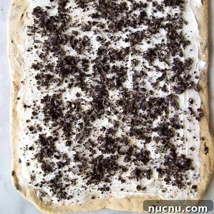 Cookies and Cream Roll Recipe: Decadent No-Bake Dessert 9 rolled dough spread with butter and topped with chopped cookies.