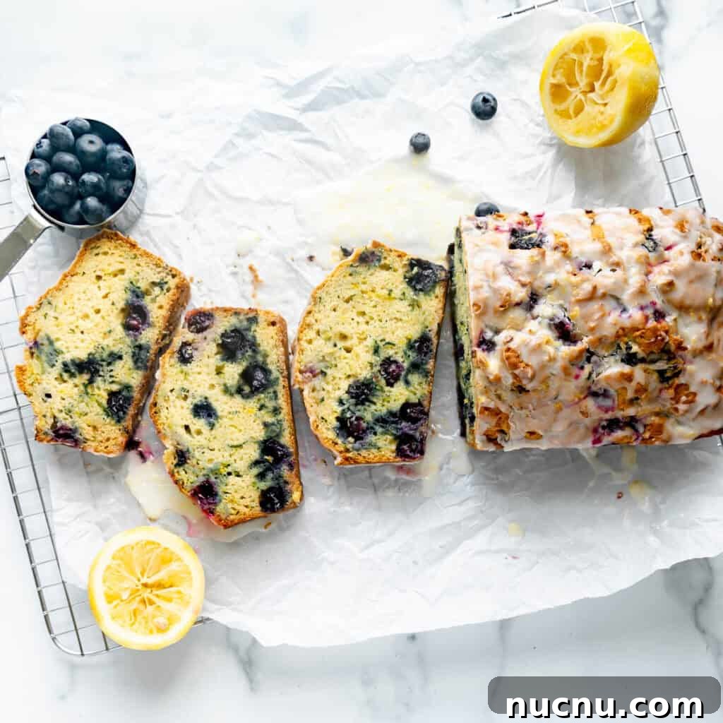 Authentic Boston Brown Bread Recipe: Steamed New England Classic 18 Blueberry Zucchini Bread on white parchment paper with lemon and blueberries around it.
