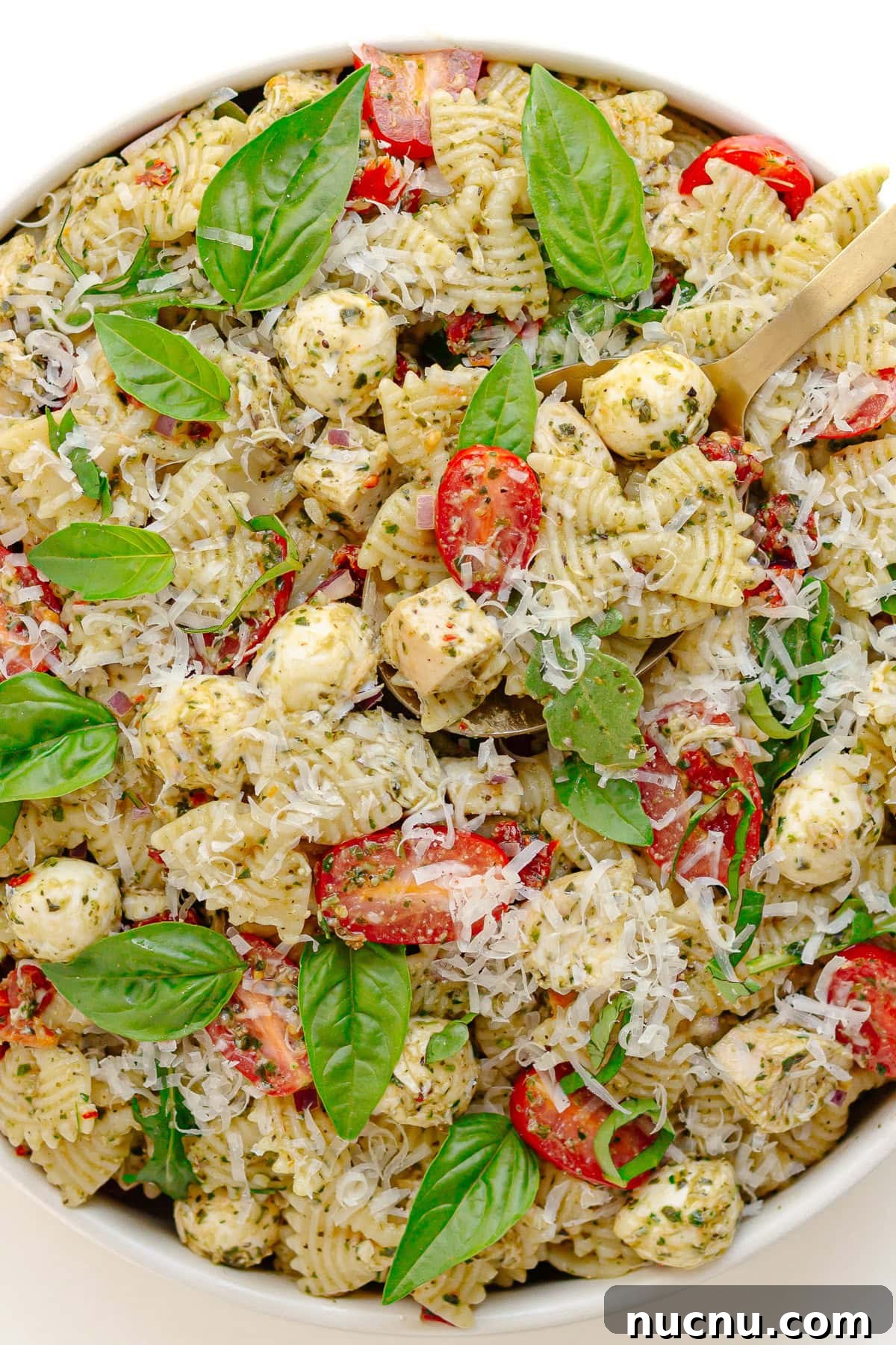 Creamy Chicken Pesto Pasta Salad with Sun-Dried Tomatoes 2 Chicken pesto pasta salad in a white serving bowl.
