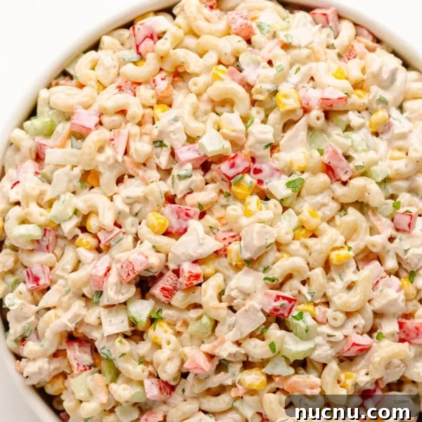 Creamy Chicken Pesto Pasta Salad with Sun-Dried Tomatoes 10 Chicken macaroni salad in a white serving bowl.