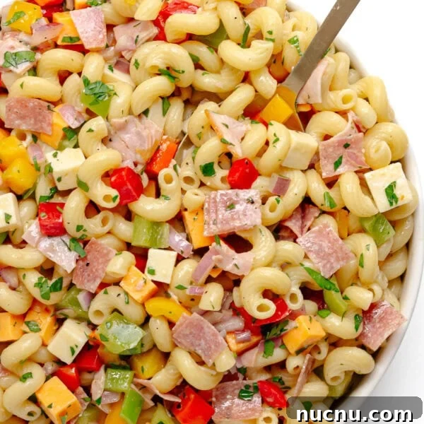 Creamy Chicken Pesto Pasta Salad with Sun-Dried Tomatoes 11 My go-to pasta salad in a white serving bowl with serving spoon.