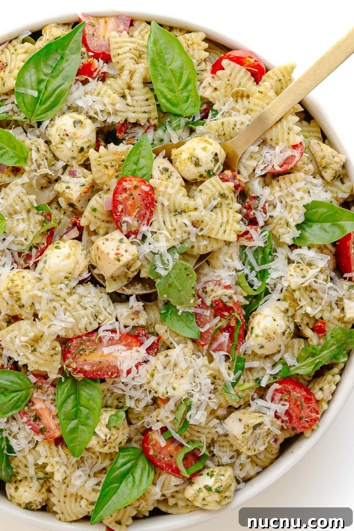 Creamy Chicken Pesto Pasta Salad with Sun-Dried Tomatoes 7 Chicken pasta salad with pesto vinaigrette in a serving bowl.