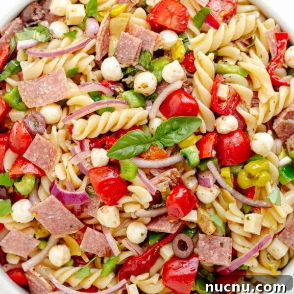 Creamy Chicken Pesto Pasta Salad with Sun-Dried Tomatoes 8 Antipasto pasta salad in a white serving bowl.