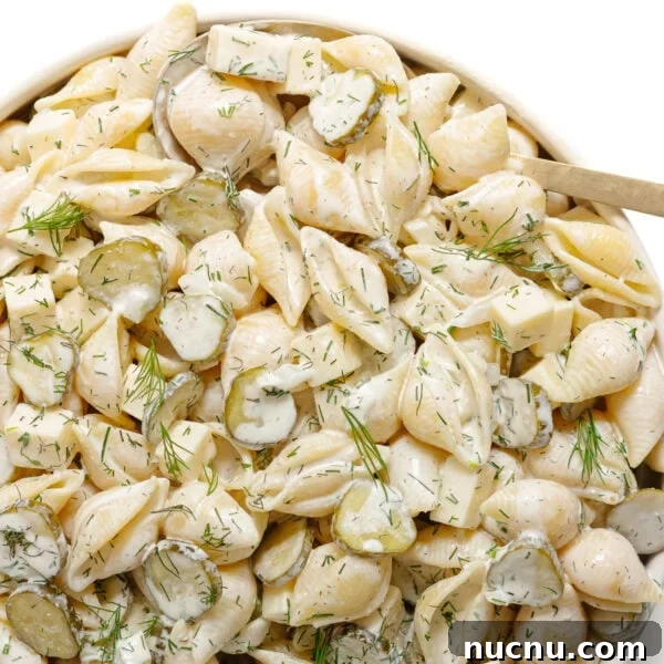 Creamy Chicken Pesto Pasta Salad with Sun-Dried Tomatoes 9 Dill pickle pasta salad in a serving bowl with serving spoon.